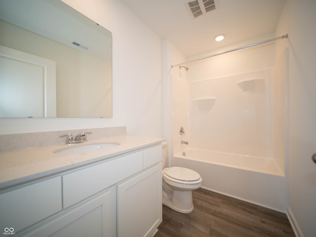 full bath with toilet, vanity, wood finished floors, and visible vents