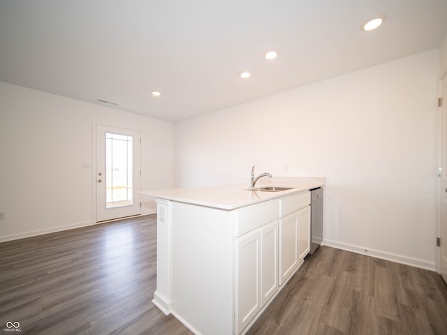 kitchen with dark wood finished floors, light countertops, white cabinetry, a sink, and recessed lighting