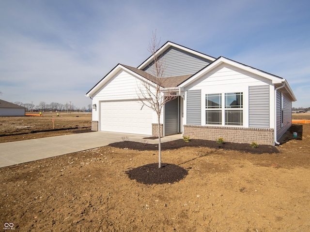 view of front of house featuring a garage, concrete driveway, and brick siding