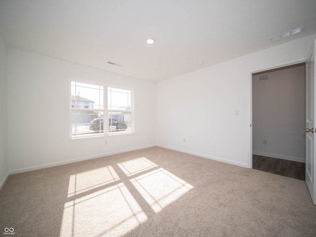 spare room featuring carpet, baseboards, and recessed lighting