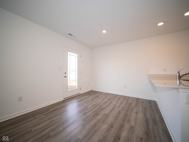 interior space featuring baseboards, visible vents, dark wood-type flooring, and recessed lighting