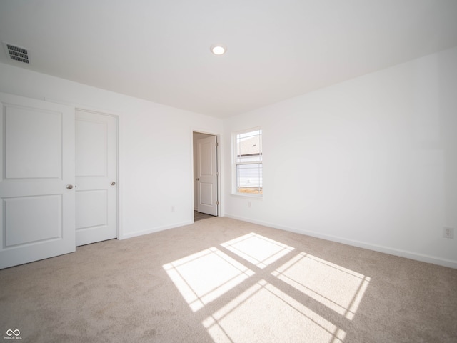 unfurnished bedroom with carpet floors, baseboards, and visible vents