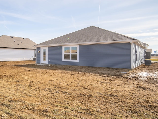 back of property with central air condition unit and roof with shingles