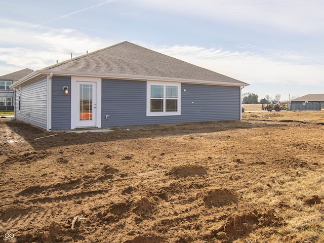 rear view of property featuring roof with shingles