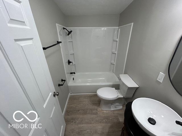 full bathroom with vanity, wood-type flooring, toilet, and shower / bath combination