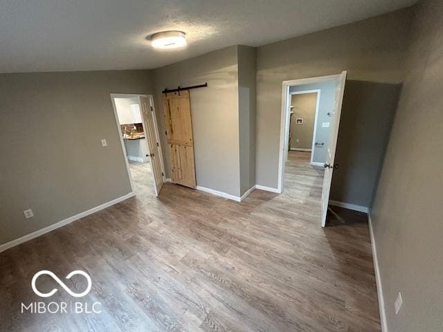 unfurnished room featuring a barn door and hardwood / wood-style floors