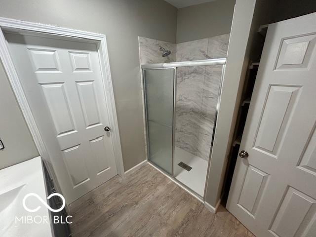 bathroom featuring an enclosed shower and hardwood / wood-style flooring