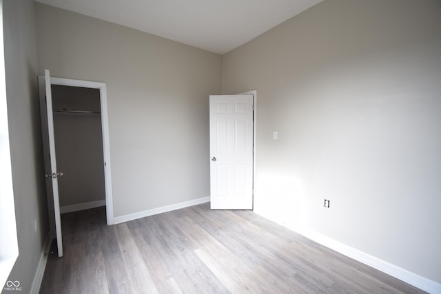 10 N Keystone Ave, Indianapolis, IN 46201 - unfurnished bedroom with a spacious closet, light hardwood / wood-style floors, and a closet