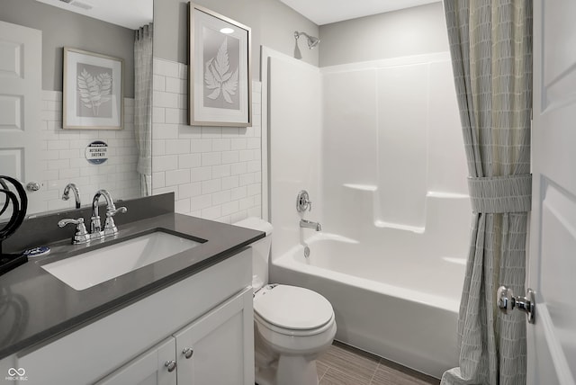 full bathroom featuring shower / tub combo with curtain, vanity, toilet, and tile walls