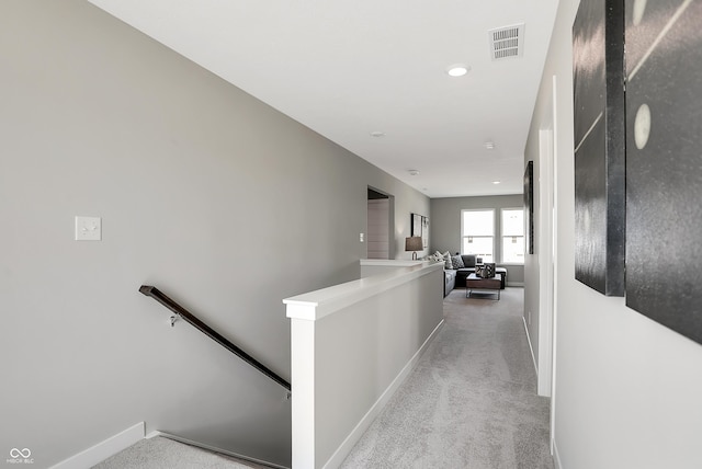 corridor featuring light colored carpet