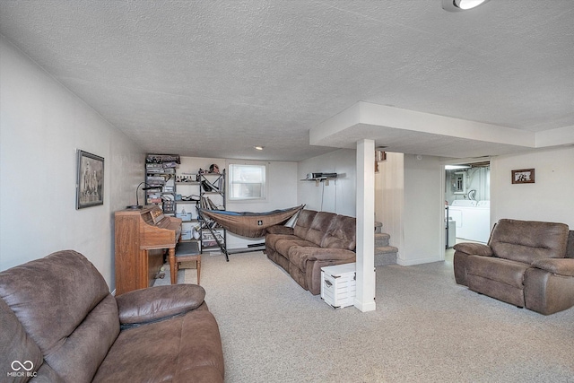 carpeted living room with a textured ceiling and washer and clothes dryer