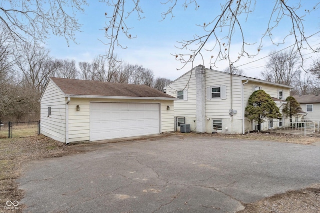 view of side of home featuring a garage, an outdoor structure, and central AC