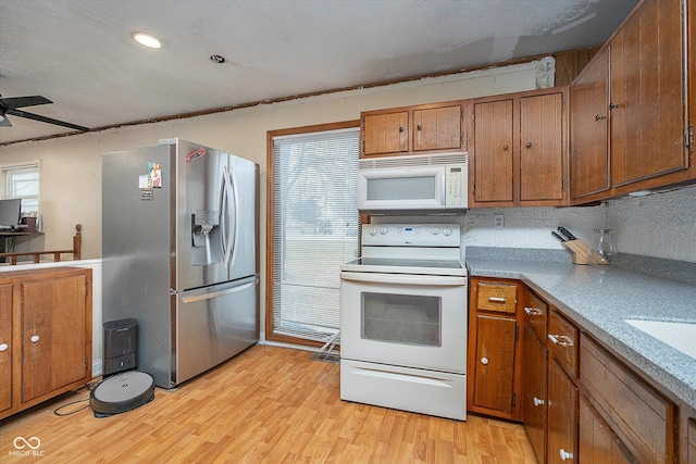 kitchen featuring ceiling fan, white appliances, and light wood-type flooring