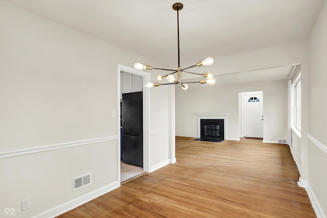 interior space with a chandelier and light wood-type flooring