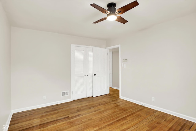 unfurnished bedroom with hardwood / wood-style floors, a closet, and ceiling fan