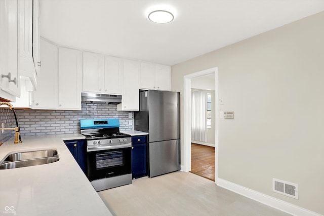 kitchen featuring appliances with stainless steel finishes, sink, white cabinets, decorative backsplash, and blue cabinetry