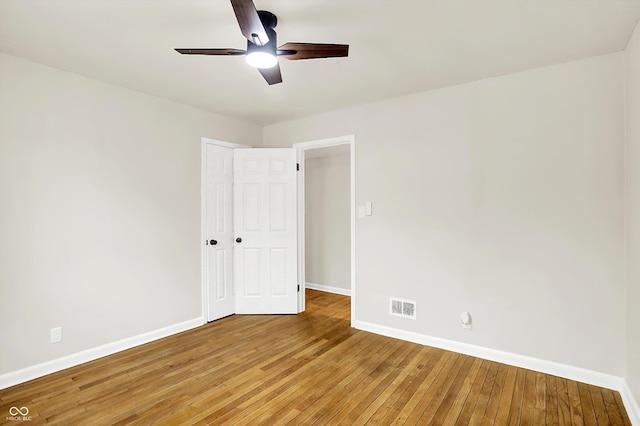 unfurnished bedroom featuring hardwood / wood-style flooring, ceiling fan, and a closet