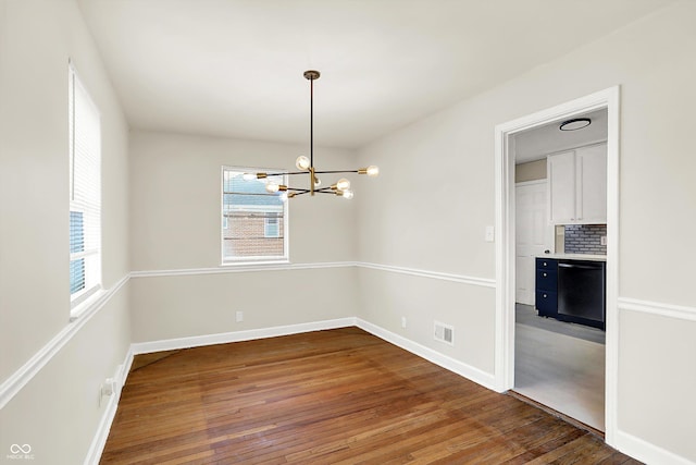 unfurnished dining area featuring dark hardwood / wood-style flooring and a chandelier