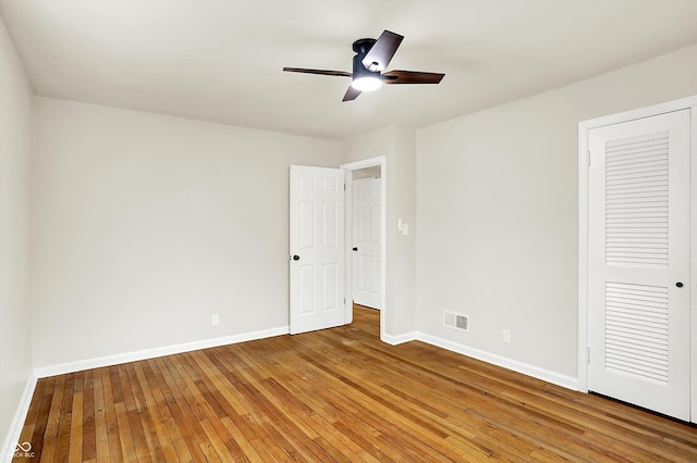 unfurnished bedroom featuring wood-type flooring, ceiling fan, and a closet