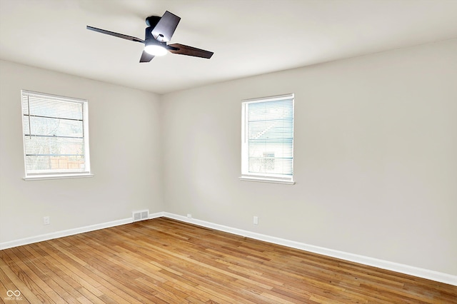 spare room with ceiling fan, plenty of natural light, and light wood-type flooring