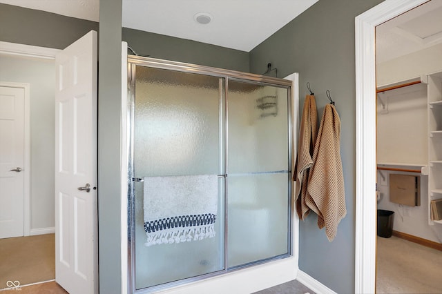 bathroom featuring a shower with door