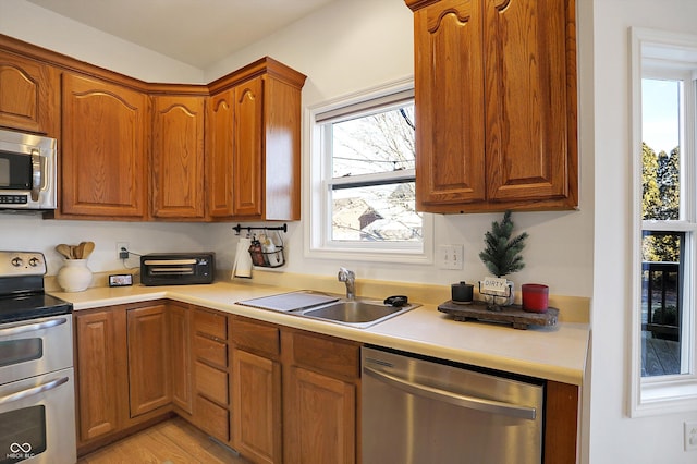 kitchen featuring stainless steel appliances, sink, and light wood-type flooring