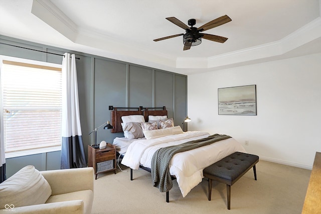 bedroom featuring light carpet, ornamental molding, a raised ceiling, and ceiling fan