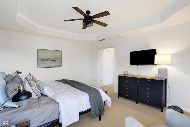 carpeted bedroom featuring crown molding, a tray ceiling, and ceiling fan