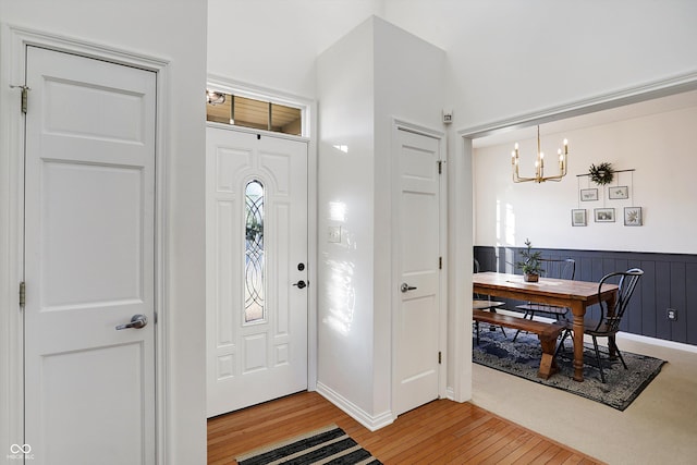 foyer entrance featuring hardwood / wood-style floors and a notable chandelier