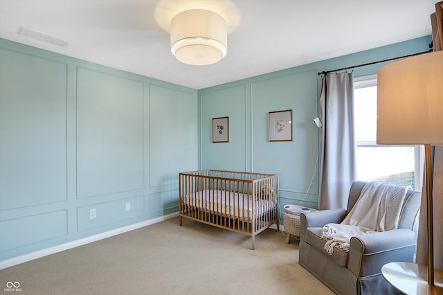 carpeted bedroom featuring a crib