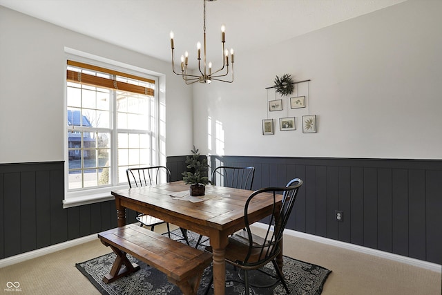 dining space featuring carpet flooring and a chandelier