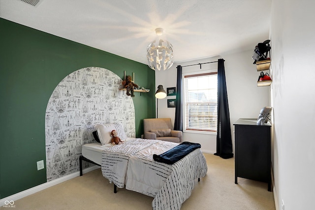 carpeted bedroom featuring an inviting chandelier