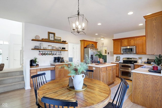 dining room with sink, an inviting chandelier, and light hardwood / wood-style flooring