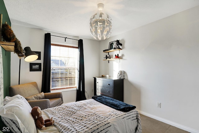 carpeted bedroom with a notable chandelier and a textured ceiling