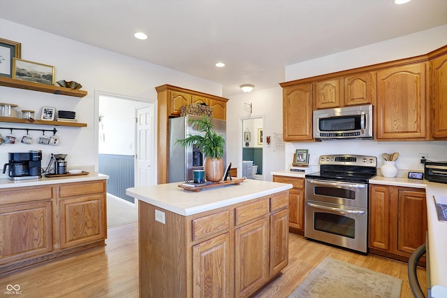 kitchen with stainless steel appliances, a kitchen island, and light hardwood / wood-style flooring