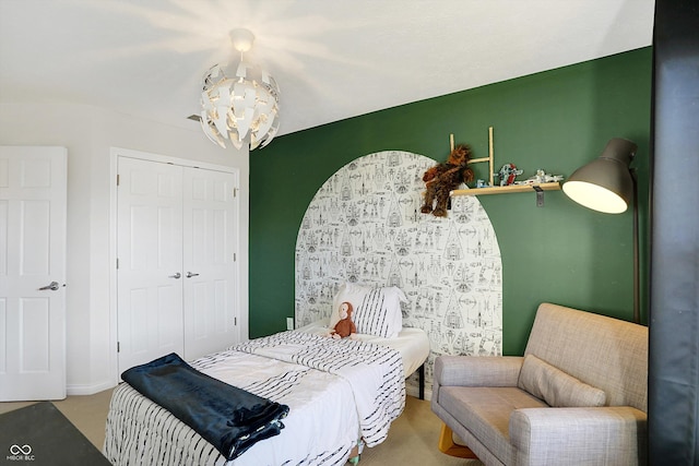 bedroom with a closet, a chandelier, and carpet flooring