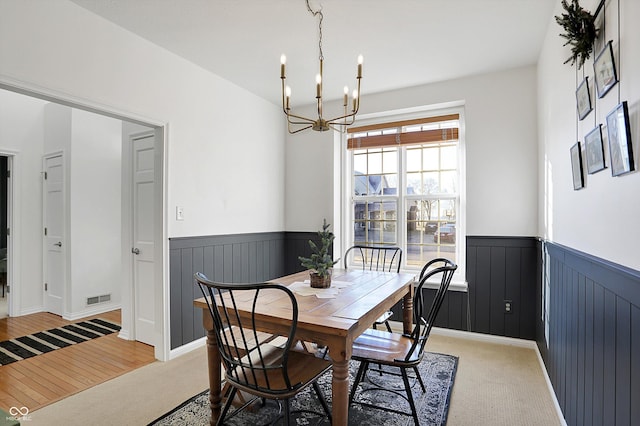 carpeted dining space featuring an inviting chandelier