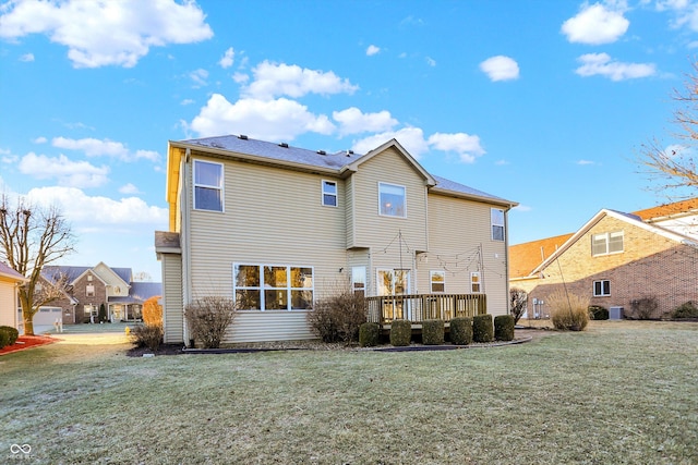 back of property with a wooden deck, a yard, and cooling unit