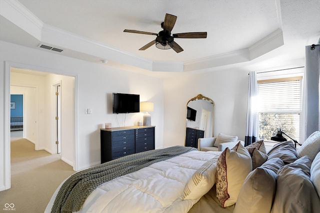 bedroom featuring light carpet, crown molding, a raised ceiling, and ceiling fan