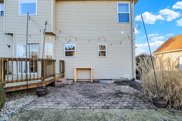 rear view of property featuring a patio and a wooden deck