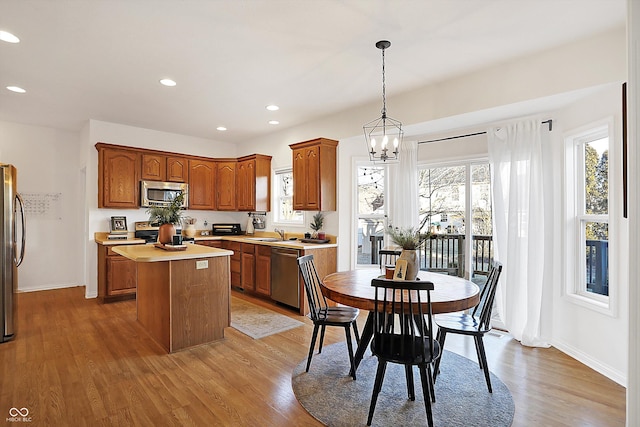 kitchen with pendant lighting, hardwood / wood-style flooring, a center island, and appliances with stainless steel finishes