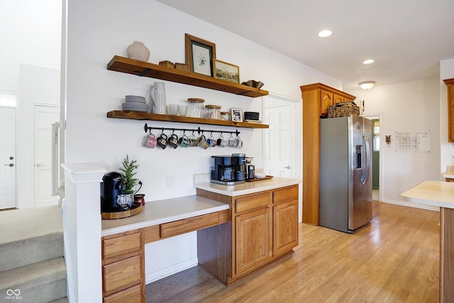 interior space featuring stainless steel refrigerator with ice dispenser and light wood-type flooring