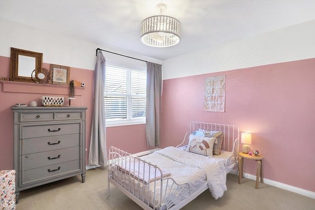 bedroom featuring light carpet and a notable chandelier