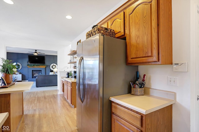 kitchen featuring stainless steel fridge, light hardwood / wood-style floors, and ceiling fan