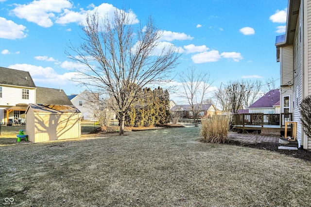 view of yard featuring a wooden deck and a storage unit