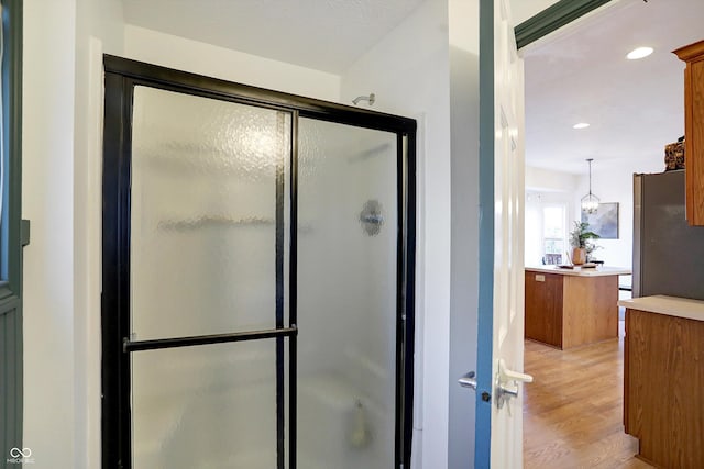 bathroom with hardwood / wood-style floors and walk in shower