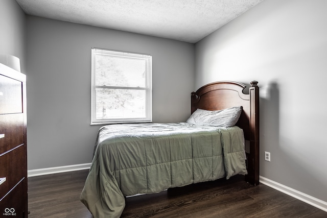 bedroom featuring dark hardwood / wood-style floors and a textured ceiling