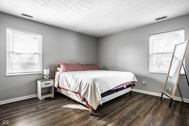 bedroom with dark hardwood / wood-style flooring and a textured ceiling