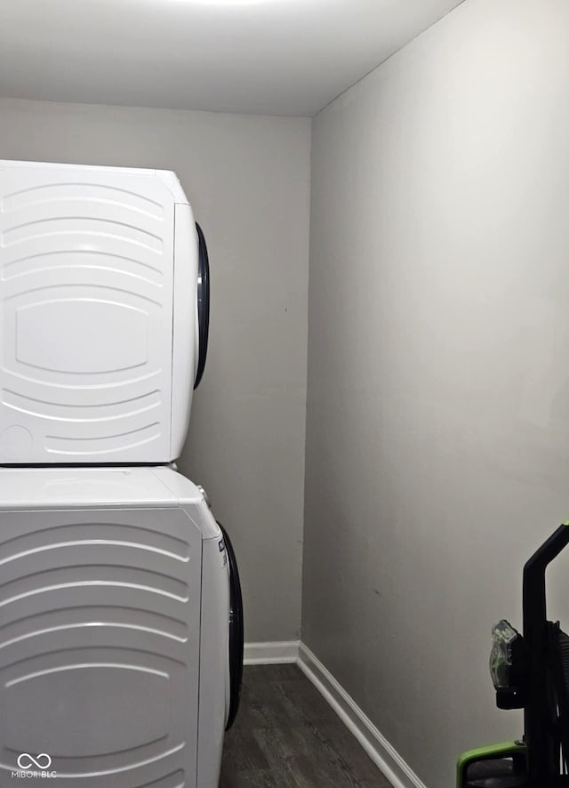 laundry area with dark hardwood / wood-style flooring and stacked washer and clothes dryer