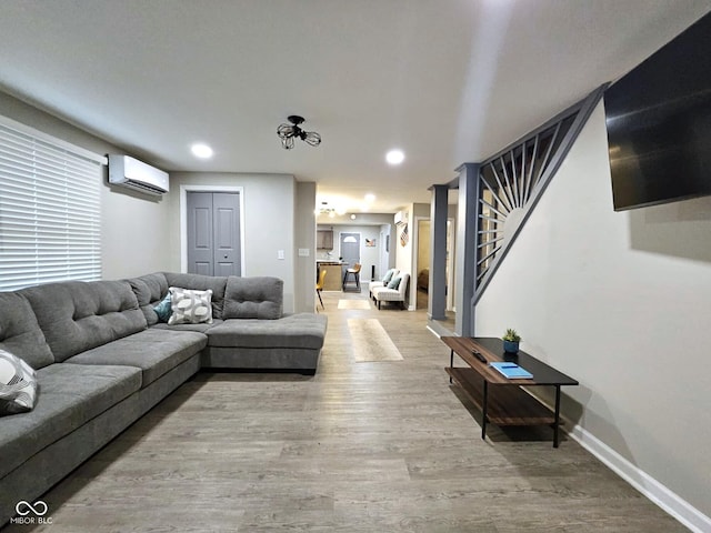 living room featuring a wall mounted air conditioner and wood-type flooring